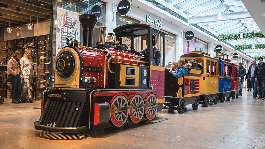 Mini Express trackless train carrying families through a shopping centre, enhancing customer experience and visitor engagement